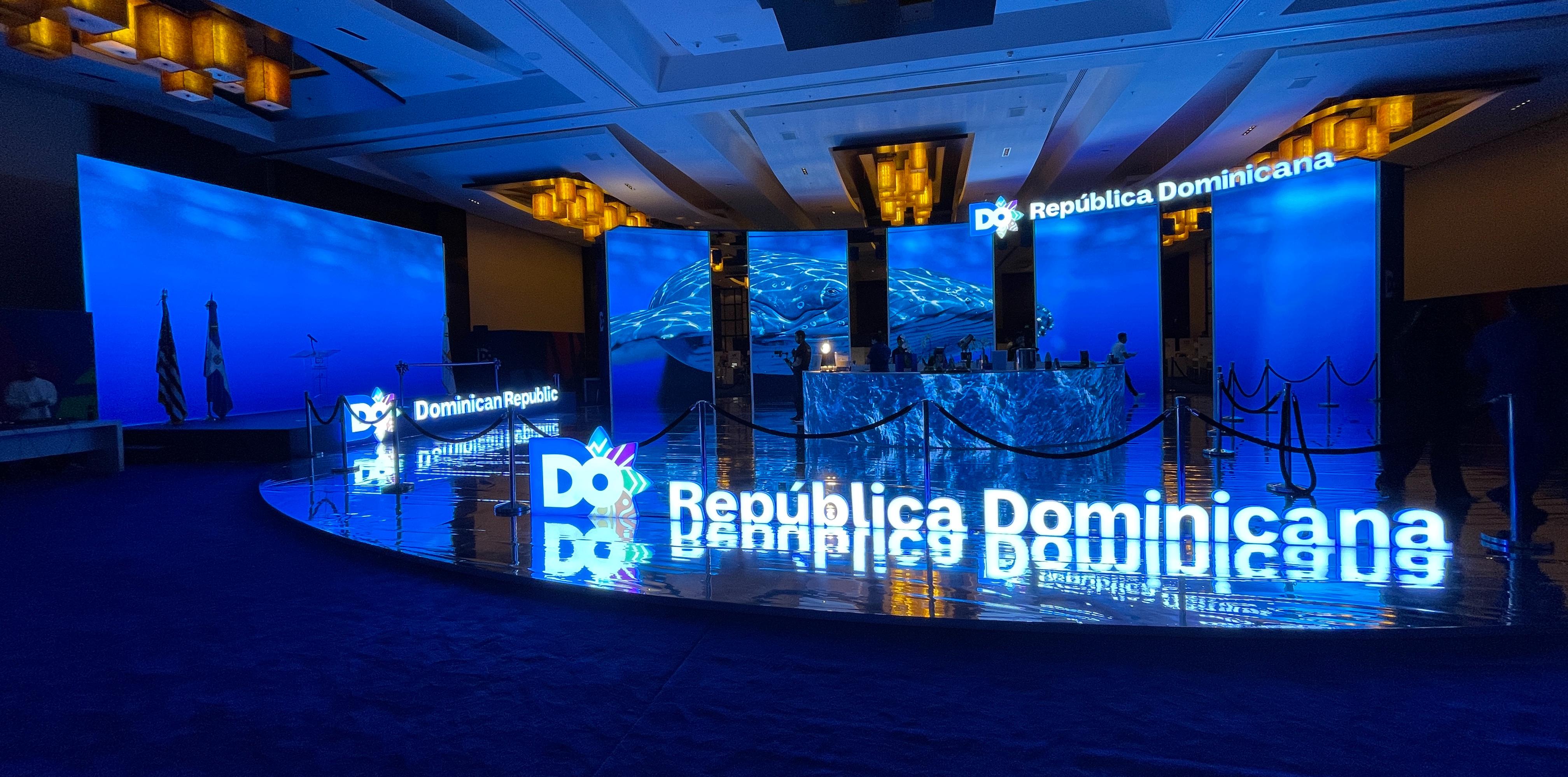 Dominican Republic Tourism Showcase: An underwater LED environment in Miami: a 3D whale crossing a stage wall and five towers, with a round LED bar in the middle of it.