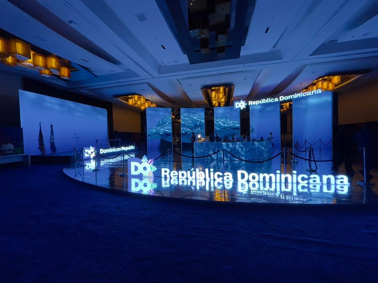 Full booth footprint on the trade-show floor showing the LED wall and embedded counter under house lights