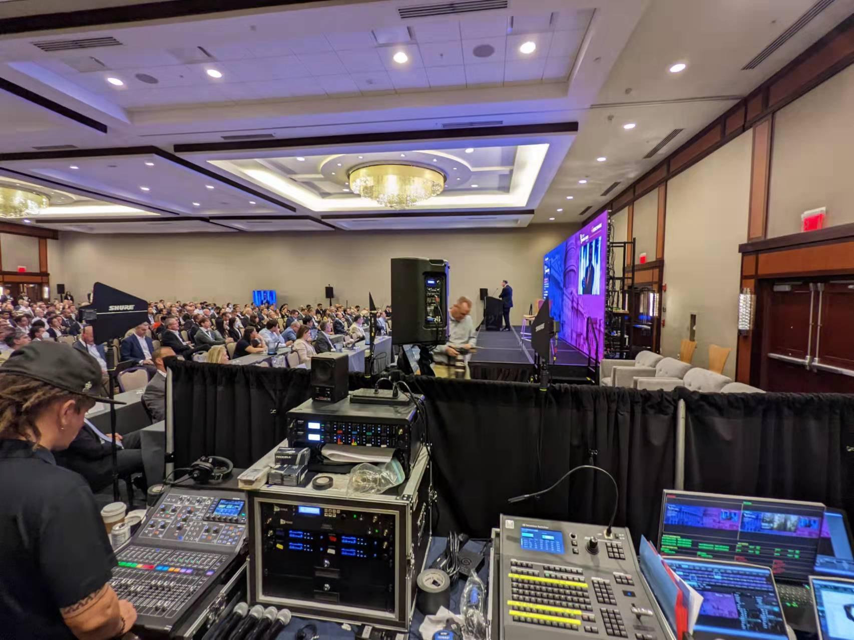 Line-array speakers and a digital mixer at a live event