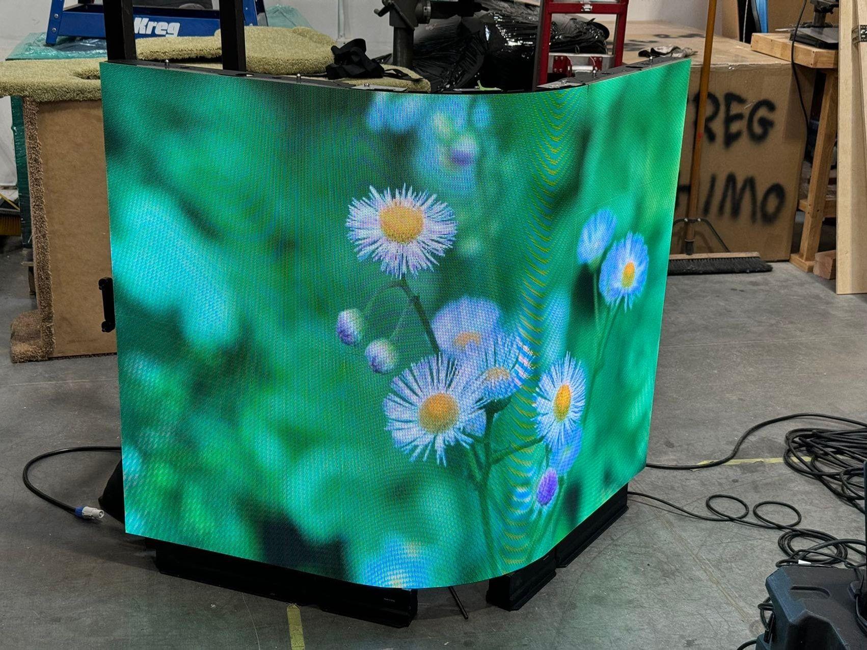 Curved LED wall wrapping a booth with flowing organic content