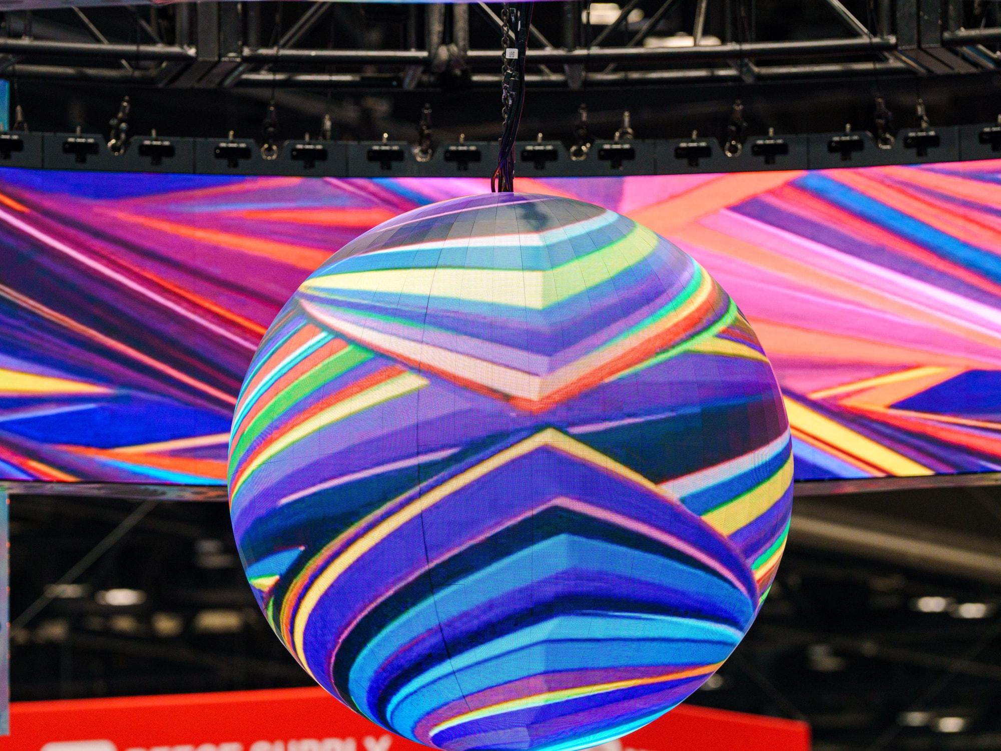 360 LED sphere suspended inside a hanging LED ring at a trade show booth