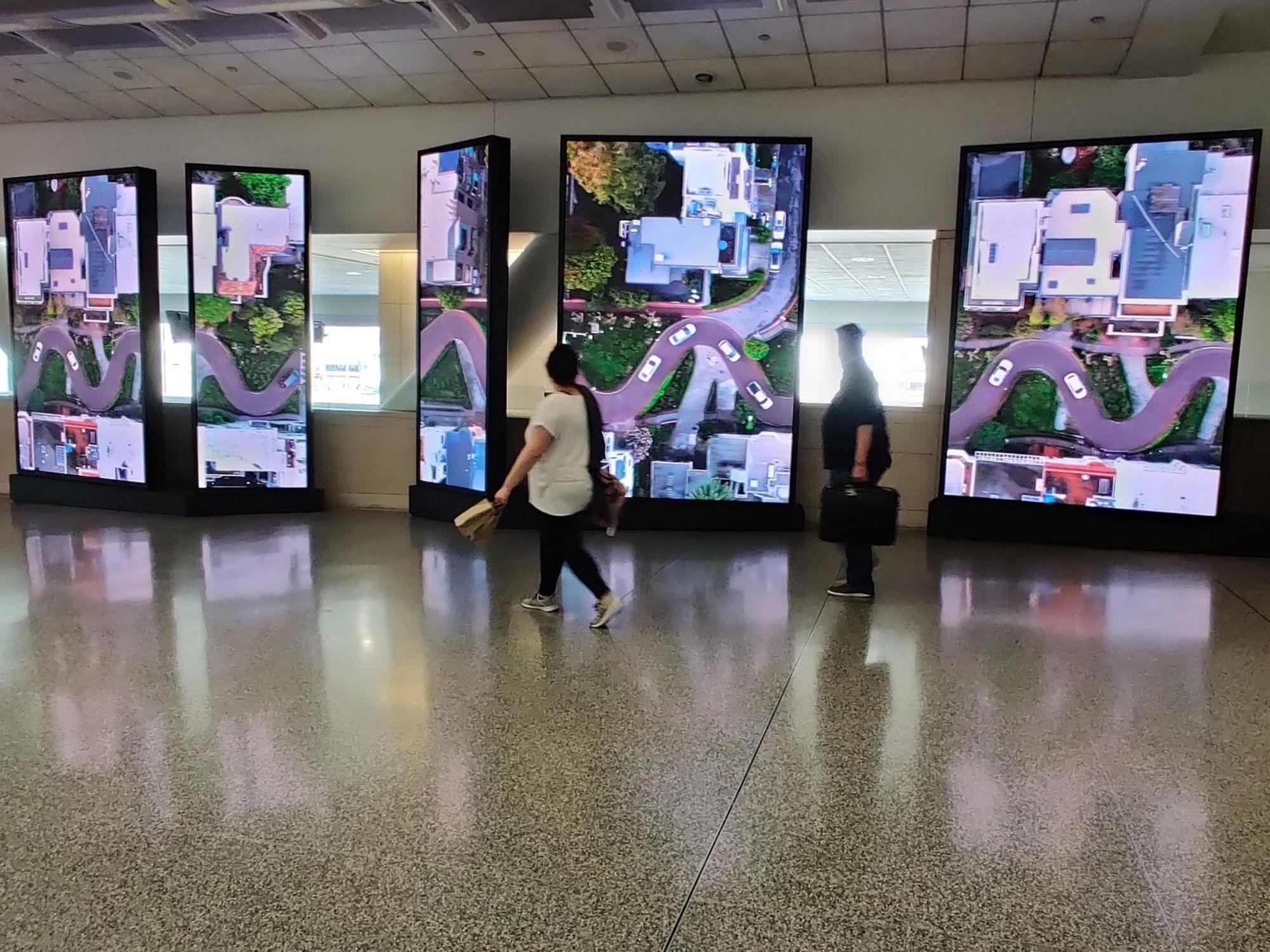 Row of LED video pillars installed in an airport concourse