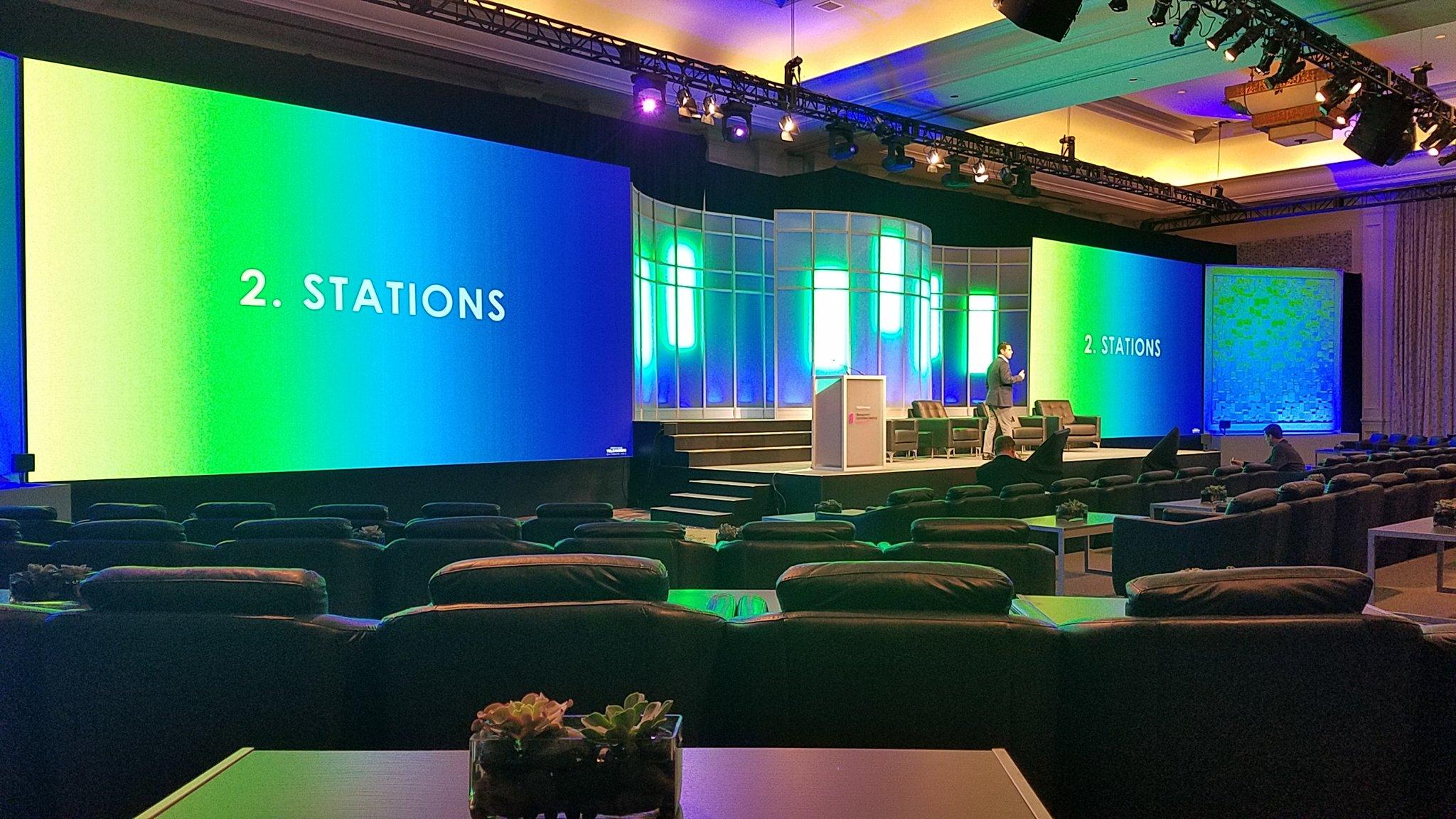 A corporate general-session ballroom lit by wide LED walls