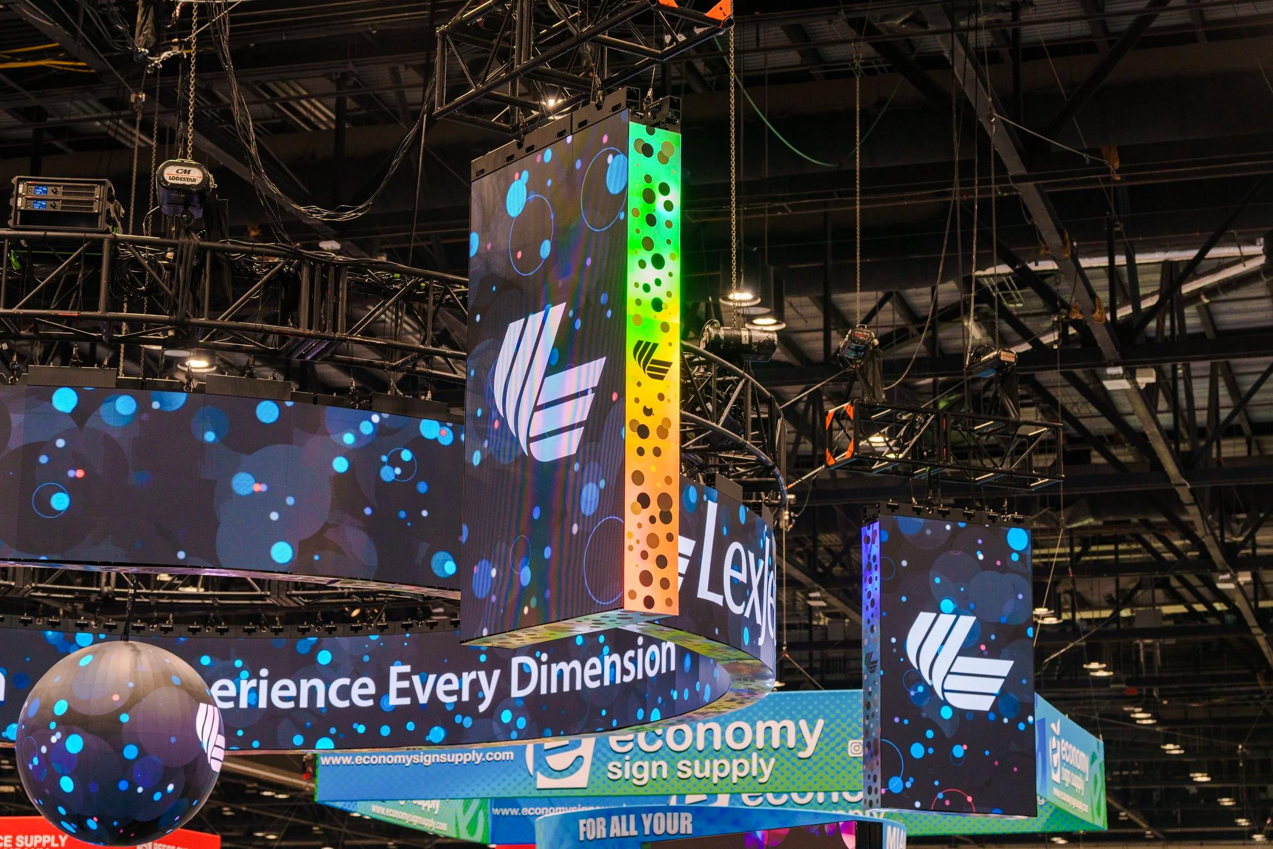LED counter anchoring the front of the booth, bright graphics facing the aisle