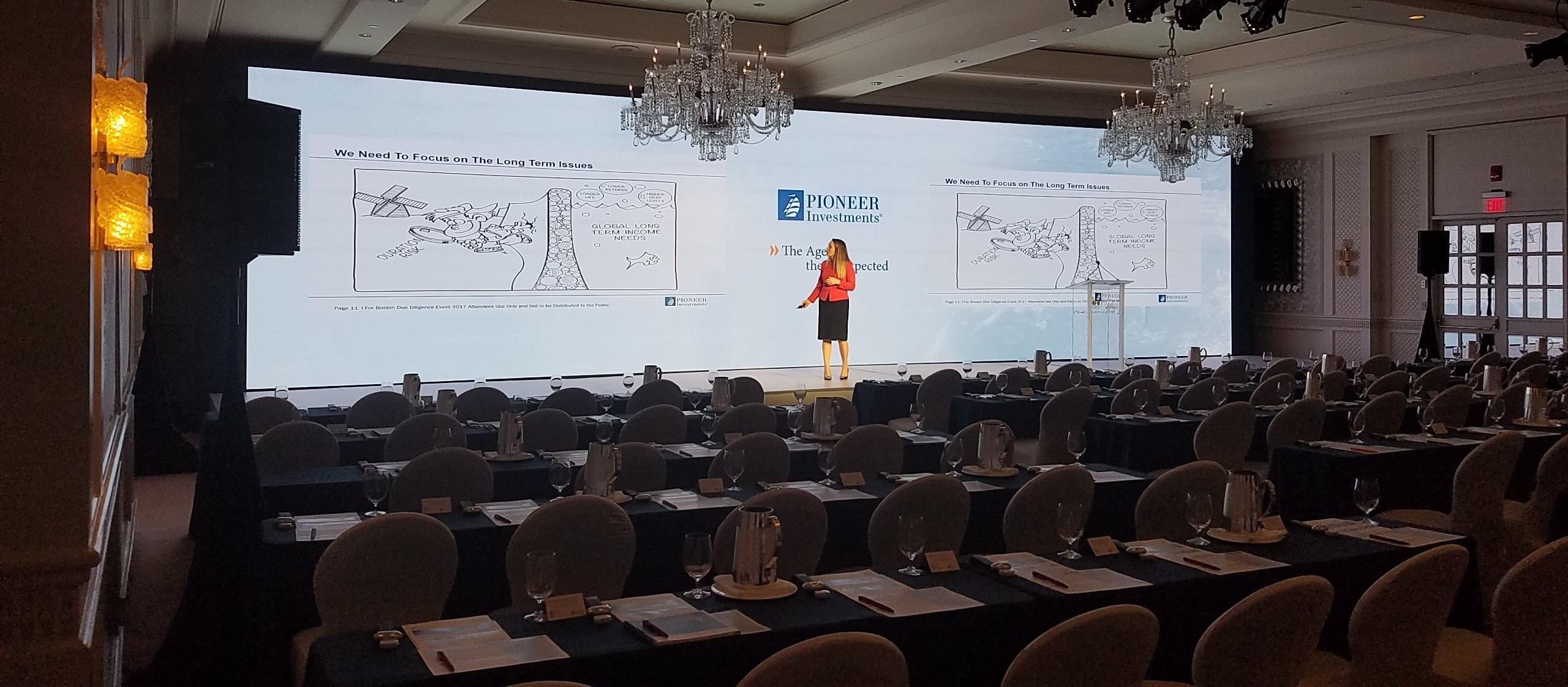 A wide LED video wall behind a live-event stage in a ballroom