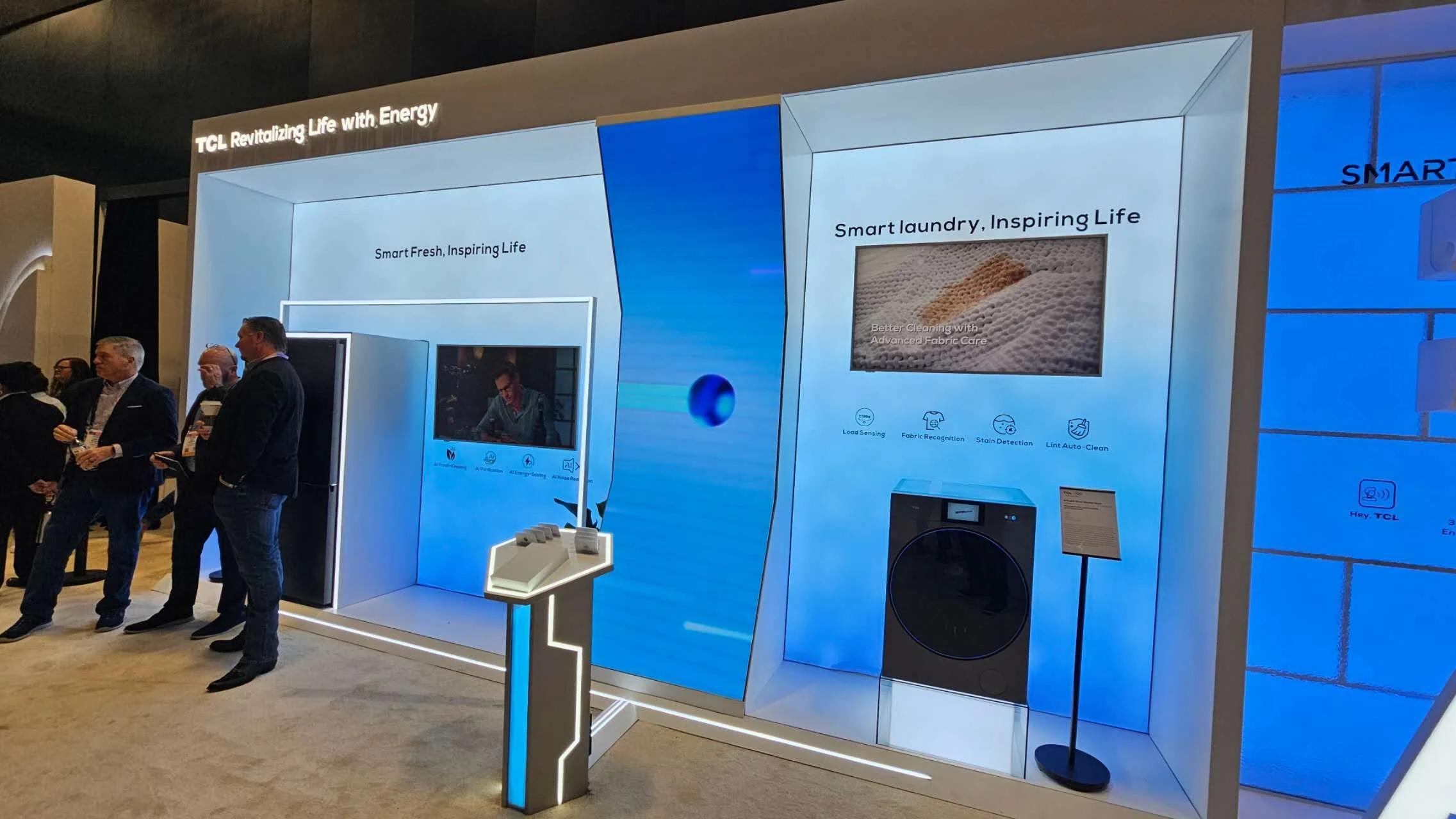 Wide view of the TCL CES exhibit floor at LVCC showing the rigged LED wall above the booth